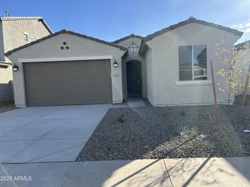 Charming single-story home featuring a neutral color palette, two car garage and desert landscaping at 17187 W Corrine Dr, Surprise, AZ 85388