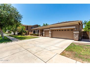 A single Gathering home featuring a neutral color palette, stone accents, and a three-car garage at 3006 E Lexington Ave, Gilbert, AZ 85234