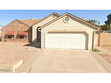 Charming single-story home with a two-car garage and low-maintenance desert landscaping in front at 6320 W Del Mar Ln, Glendale, AZ 85306
