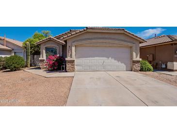 Charming home featuring a two-car garage, desert landscaping and stone veneer accents at 8660 E Nido Ave, Mesa, AZ 85209