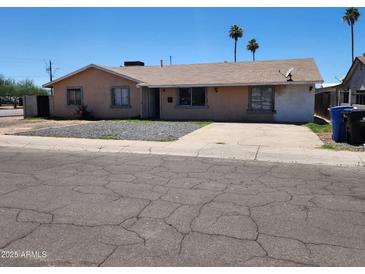 Charming single-story home featuring a xeriscaped front yard, driveway, and neutral-toned stucco exterior at 1602 N 57Th Ave, Phoenix, AZ 85035