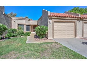 Charming single-story home featuring a tile roof, stucco exterior, and a well-maintained front yard with green grass at 19120 N 98Th Ln, Peoria, AZ 85382