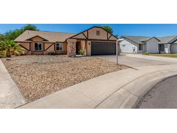Charming single-story home with a two-car garage, rock landscaping, and a well-maintained front yard at 647 W Mission Dr, Chandler, AZ 85225