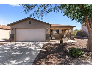 Charming single-story home featuring a two-car garage, front porch, and desert landscaping at 1057 E Silversmith Trl, San Tan Valley, AZ 85143