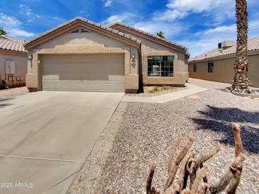 Charming single-story home with a two-car garage, neutral stucco, concrete driveway, and desert landscaping at 13030 W Hearn Rd, El Mirage, AZ 85335