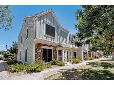 Charming two-story townhome with light-blue wood siding and a brick accent on the lower level at 1600 N Saba St # 214, Chandler, AZ 85225