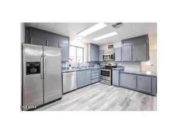 Charming kitchen featuring stainless steel appliances, gray cabinets, and a modern countertop at 4065 E University Dr # 436, Mesa, AZ 85205