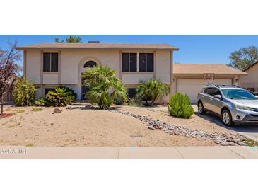 Two-story home with desert landscaping, a basketball hoop, and a beige stucco exterior at 7259 E Glencove St, Mesa, AZ 85207