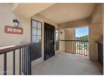 Inviting condo front entrance with a balcony, a secure screen door, and an exterior light at 8314 N 21St Dr # K208, Phoenix, AZ 85021