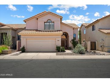 Charming two-story home with a tile roof, desert landscaping, and a two-car garage at 14186 N 100Th Pl, Scottsdale, AZ 85260