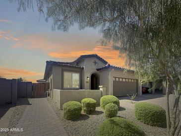 Charming single-story home featuring mature landscaping, a brick walkway, and an attached two-car garage at 24776 N 171St Ln, Surprise, AZ 85387