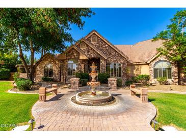 Stunning stone home with a circular driveway and a beautiful water fountain feature at 2558 E Page Ct, Gilbert, AZ 85234