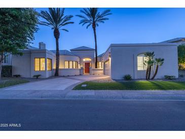 Stunning modern home exterior at dusk with lush landscaping and a circular driveway at 7878 E Gainey Ranch Rd # 36, Scottsdale, AZ 85258