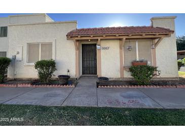 Charming single-story home featuring a tiled roof overhang and tidy landscaping at the front entrance at 8063 N 31St Ln, Phoenix, AZ 85051