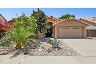 Inviting single-story home featuring a well-manicured desert front yard and two-car garage at 10367 E Wood Dr, Scottsdale, AZ 85260