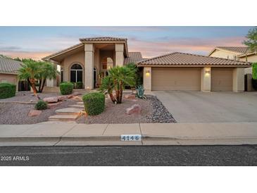Inviting home featuring a three car garage, desert landscaping, and a covered entry at 4146 N Lomond --, Mesa, AZ 85215
