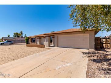 Charming single-story home with a well-maintained yard and a spacious two-car garage at 662 W Laguna Azul Ave, Mesa, AZ 85210