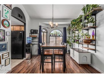 Bright dining room with wood floors, black accents, and lots of natural light from the large arched windows at 850 S River Dr # 2065, Tempe, AZ 85281
