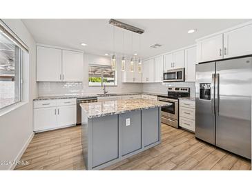 Beautiful kitchen featuring stainless steel appliances, granite countertops, and a central island with pendant lights at 1017 S Allen --, Mesa, AZ 85204