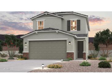 Charming two-story home featuring a spacious garage and beautifully landscaped front yard with decorative lighting at 17391 W Jessie Ln, Surprise, AZ 85387