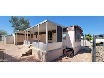 Cozy home featuring a screened porch, small yard, and classic mobile home design, awaiting personal touches at 3541 W Monona Dr, Glendale, AZ 85308