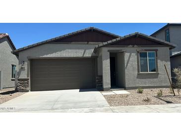 Charming single-story home featuring a two-car garage and desert landscaping at 5657 S 253Rd Ave, Buckeye, AZ 85326
