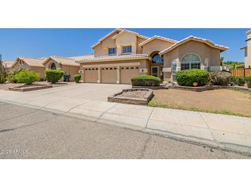 Inviting two-story home featuring a three-car garage and well-maintained front yard landscaping at 728 W Sandra Ter, Phoenix, AZ 85023
