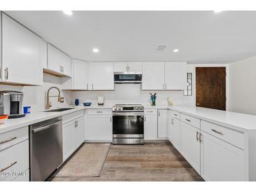 Updated kitchen with white cabinets, stainless appliances, and wood-look floors is move-in ready at 7920 E Camelback Rd # 508, Scottsdale, AZ 85251