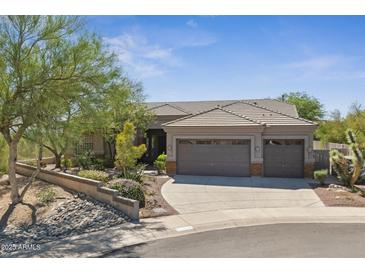 Charming desert home boasts a three-car garage, tile roof, and lush desert landscaping at 11008 N 119Th Pl, Scottsdale, AZ 85259
