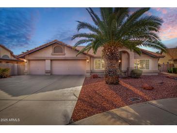 Charming single-story home with a well-manicured front yard and a three-car garage at 11065 W Runion Dr, Peoria, AZ 85373