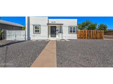 Charming white home featuring a black door, black trimmed windows, and desert landscaping at 1118 N 18Th St, Phoenix, AZ 85006