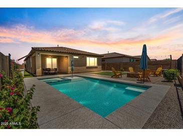 Backyard pool and spa with seating area, surrounded by updated landscaping and attractive sunset backdrop at 11951 W Wier Ave, Avondale, AZ 85323