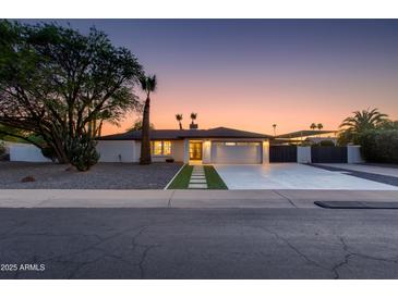 Charming single-story home with desert landscaping, a modern front entrance, and spacious driveway at 14012 N 57Th Pl, Scottsdale, AZ 85254