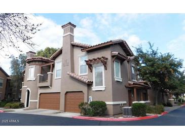 Stylish townhome with a private garage and well-maintained landscaping creates an inviting curb appeal at 14250 W Wigwam Blvd # 1723, Litchfield Park, AZ 85340