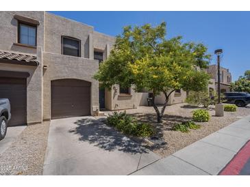 Charming townhome exterior with private garage and well-maintained desert landscaping and a tree at 1886 E Don Carlos Ave # 136, Tempe, AZ 85281