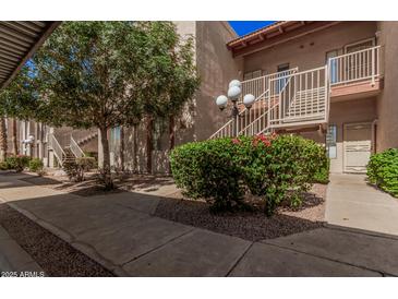 An apartment building exterior showing landscape, staircases, and walkways at 205 N 74Th St # 110, Mesa, AZ 85207
