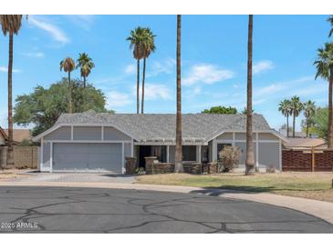 Charming single-story home with well-manicured lawn and mature palm trees at 4812 W Butler Dr, Chandler, AZ 85226