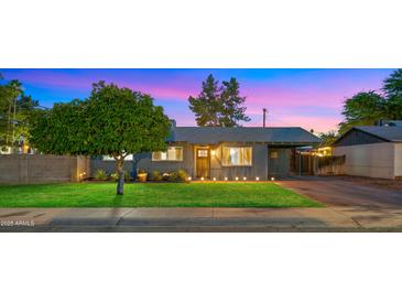 Charming single story home with fresh green lawn, landscape lighting and mature shade tree at 7543 E Portland St, Scottsdale, AZ 85257