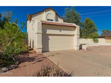 Two-story home featuring a two-car garage, red tile roof, and low-maintenance desert landscaping at 1621 N Chippewa Dr, Chandler, AZ 85224