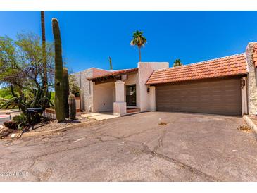 Southwest style home with a brown tile roof, stucco walls, desert landscaping, and a two car garage at 1831 N 77Th St, Scottsdale, AZ 85257