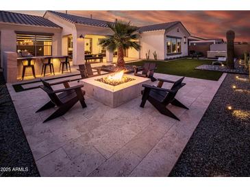 Inviting backyard featuring a fire pit and lounge seating, perfect for outdoor entertaining at 22837 E Orchard Ln, Queen Creek, AZ 85142
