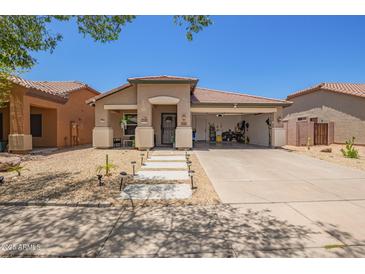 Charming single-story home with xeriscaped yard, covered porch, and convenient drive-through garage at 518 S 114Th Ave, Avondale, AZ 85323