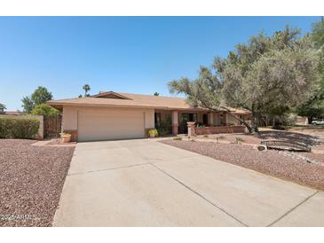 Charming single story home featuring a two-car garage, mature trees, and a well-maintained landscape at 5410 E Poinsettia Dr, Scottsdale, AZ 85254