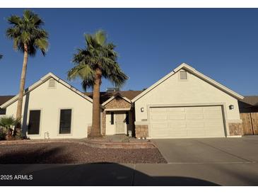 Charming single-story home with a well-manicured front yard and beautiful desert landscaping including mature palm trees at 10029 S 44Th St, Phoenix, AZ 85044