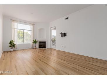 Bright living room features a fireplace, hardwood floors and large windows for natural light at 11640 N Tatum Blvd # 2012, Phoenix, AZ 85028