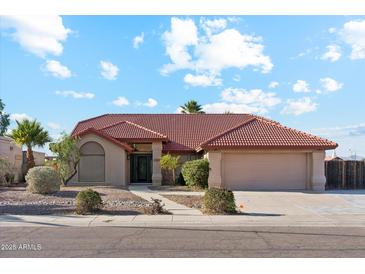 Charming single-story home featuring a well-manicured front yard and a classic red tile roof at 1192 E Sunset Dr, Casa Grande, AZ 85122