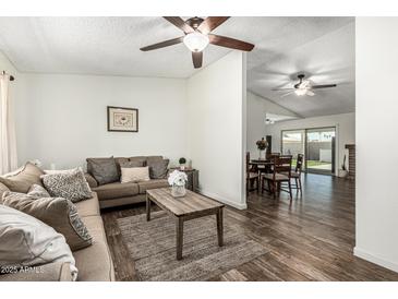 Inviting living room with a comfortable brown sofa, area rug, and open access to the dining area at 18818 N 12Th Ave, Phoenix, AZ 85027