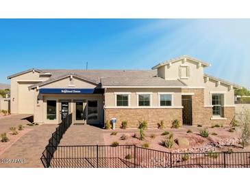 A charming single-Gathering house featuring a stone facade, desert landscaping, and a well-manicured front yard at 19910 W Mulberry Dr, Buckeye, AZ 85396