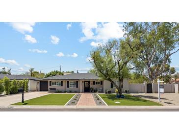 Charming single-story home with manicured lawn, brick pathway, and inviting curb appeal at 3201 E Colter St, Phoenix, AZ 85018