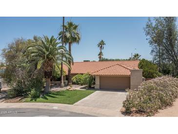 Charming single-story home with a tile roof, lush landscaping, and a two-car garage at 6101 E Beck Ln, Scottsdale, AZ 85254